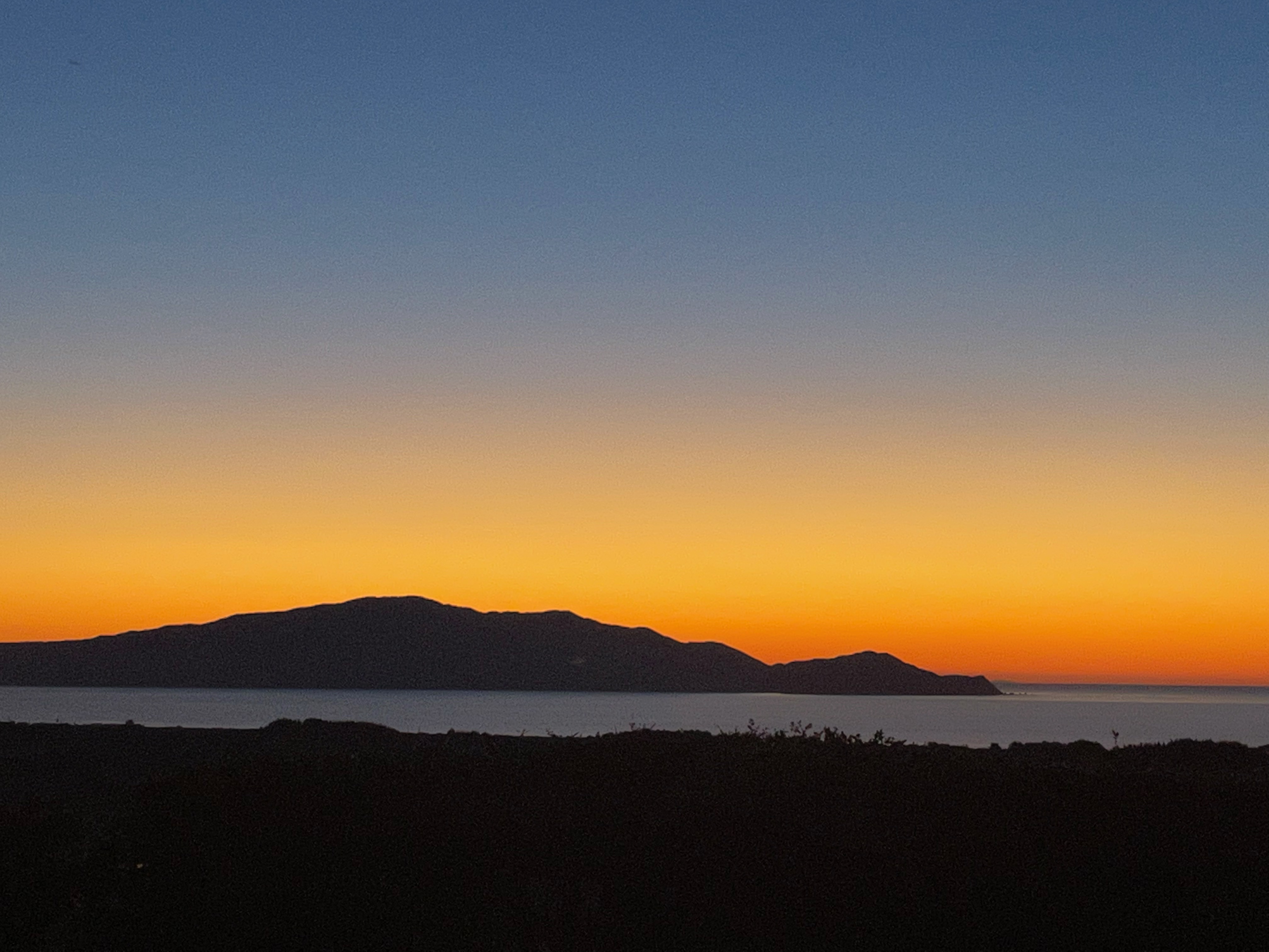 Kāpiti Island silhouetted against a sunset sky